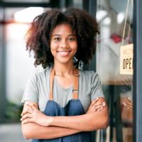 A confident business owner outside of her coffee shop.