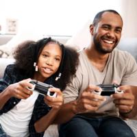 A father play video games with his daughter.