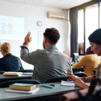 A man raises his hand in class