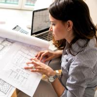 A woman reviews an architectural drawing.