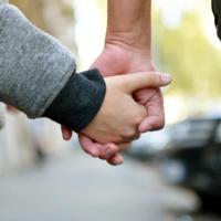 A parent and child hold hands