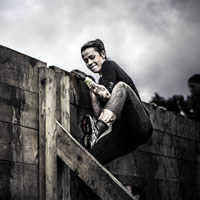 Woman successfully climbing over a tall wall.