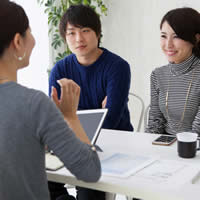 A couple speaks with a financial planner or real estate agent.