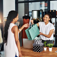 A woman making a purchase from a clothing store.