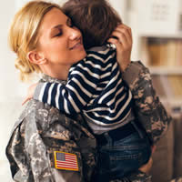 A female service member hugging her young son.