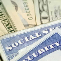 Social Security cards resting on a pile of twenty dollar bills